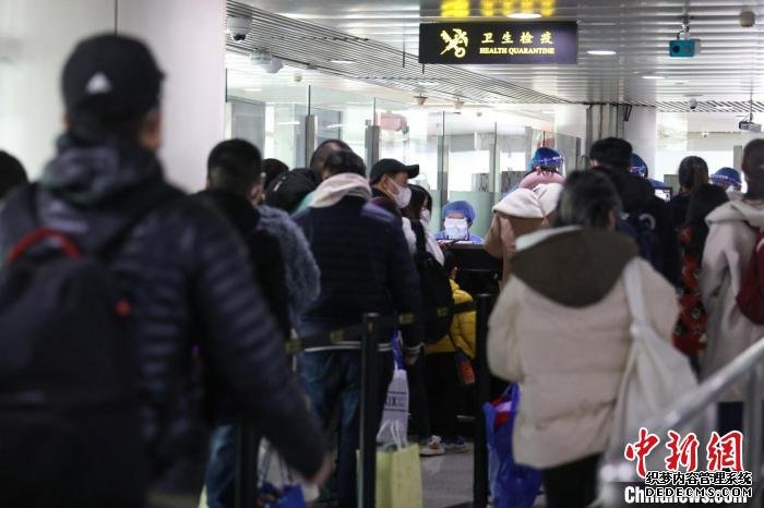 青岛流亭机场海关关员对旅客体温进行监测。　解豪 摄