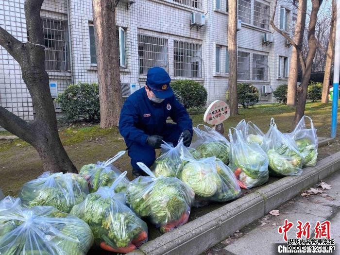 图为消防员正在为居民分发蔬菜 湖北省消防救援总队供图 摄