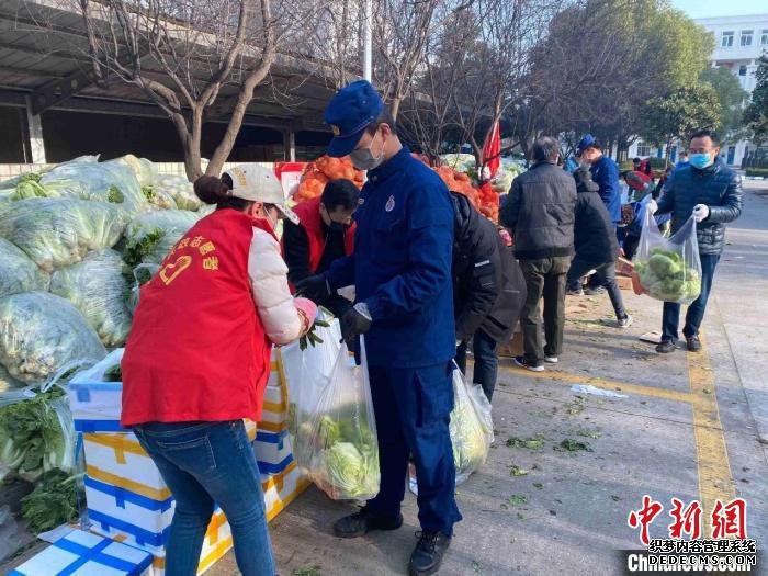 图为消防员正在为居民分发蔬菜 湖北省消防救援总队供图 摄